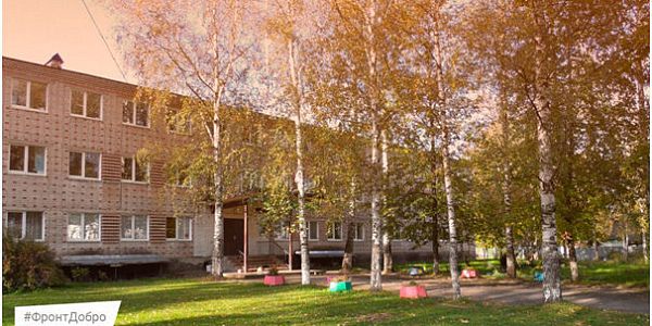 Трёхэтажное кирпичное здание среди берёз с жёлтой листвой осенью