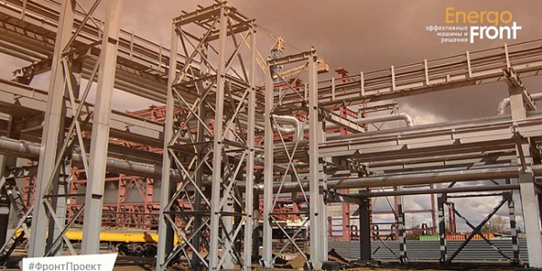 Стальные каркасы и трубопроводы на стройплощадке под облачным небом