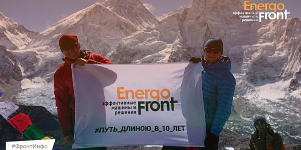 Двое альпинистов с баннером Energofront на фоне снежных горных пиков