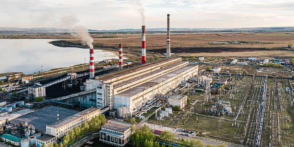 Аэроснимок тепловой электростанции с четырьмя полосатыми трубами у водоёма