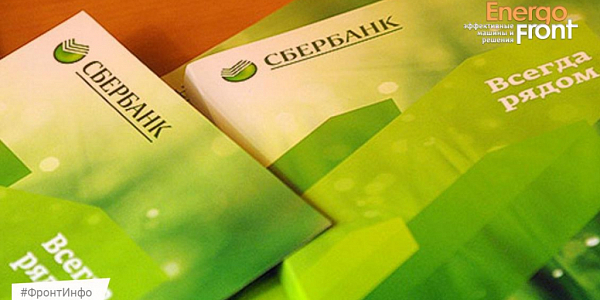 Зелёные буклеты Сбербанка со слоганом Всегда рядом на деревянном столе